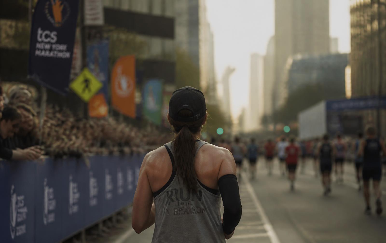 A runner on a city marathon course lined with spectators